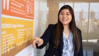 PhD student pointing towards research poster.